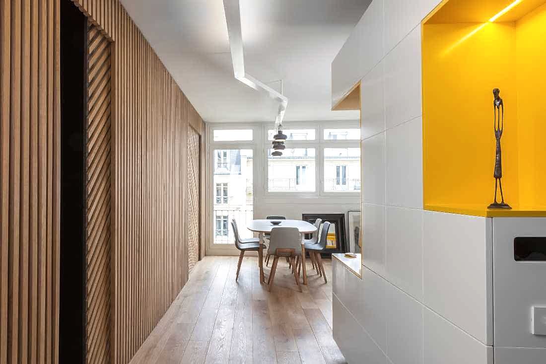 Entrée et pièce à vivre ouverte de l'appartement avec luminaire sur mesure
