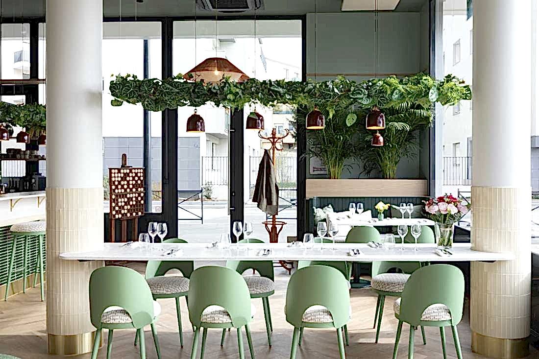 Architecture intérieur d'un restaurant eco-responsable - table entre 2 colonnes avec vue sur l'entrée
