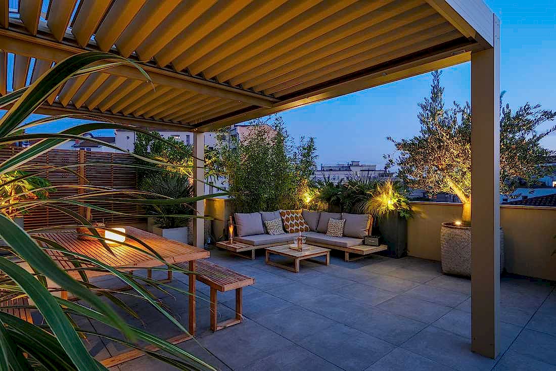 Terrasse bioclimatique avec pergola - espace détente avec canapé d'angle - vue nocturne